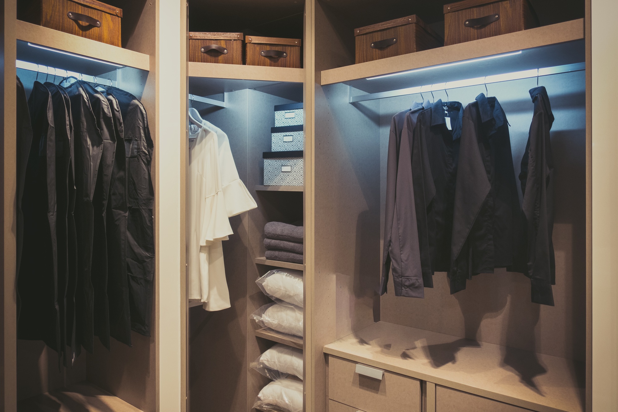 Black and white cloths hanging in wooden wardrobe at home