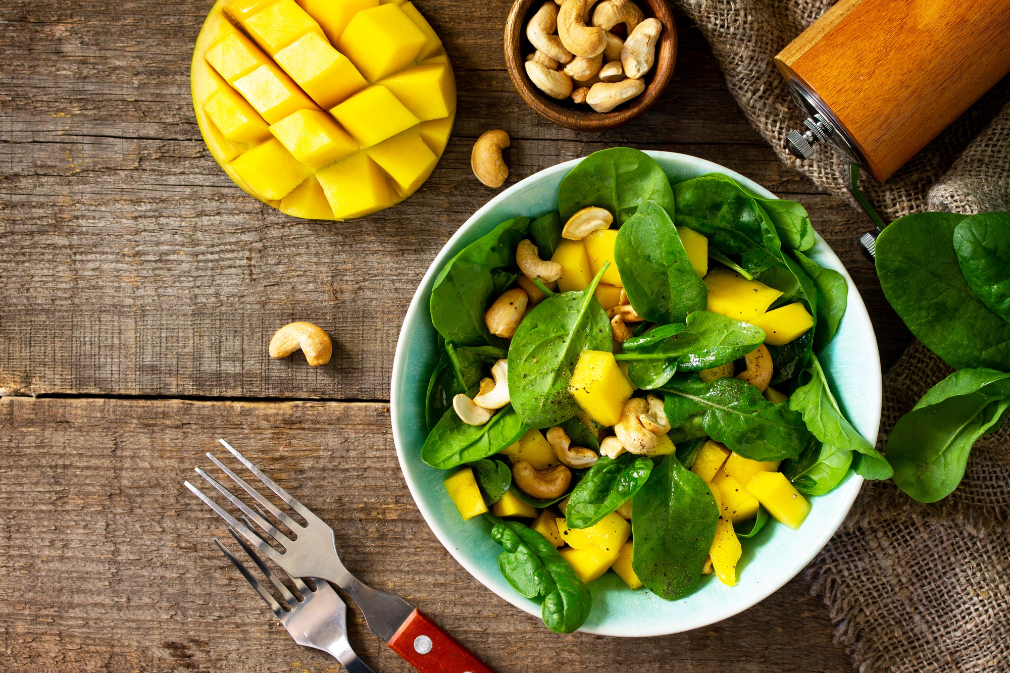 Healthy salad with spinach, mango, pecan and vinaigrette dressing.