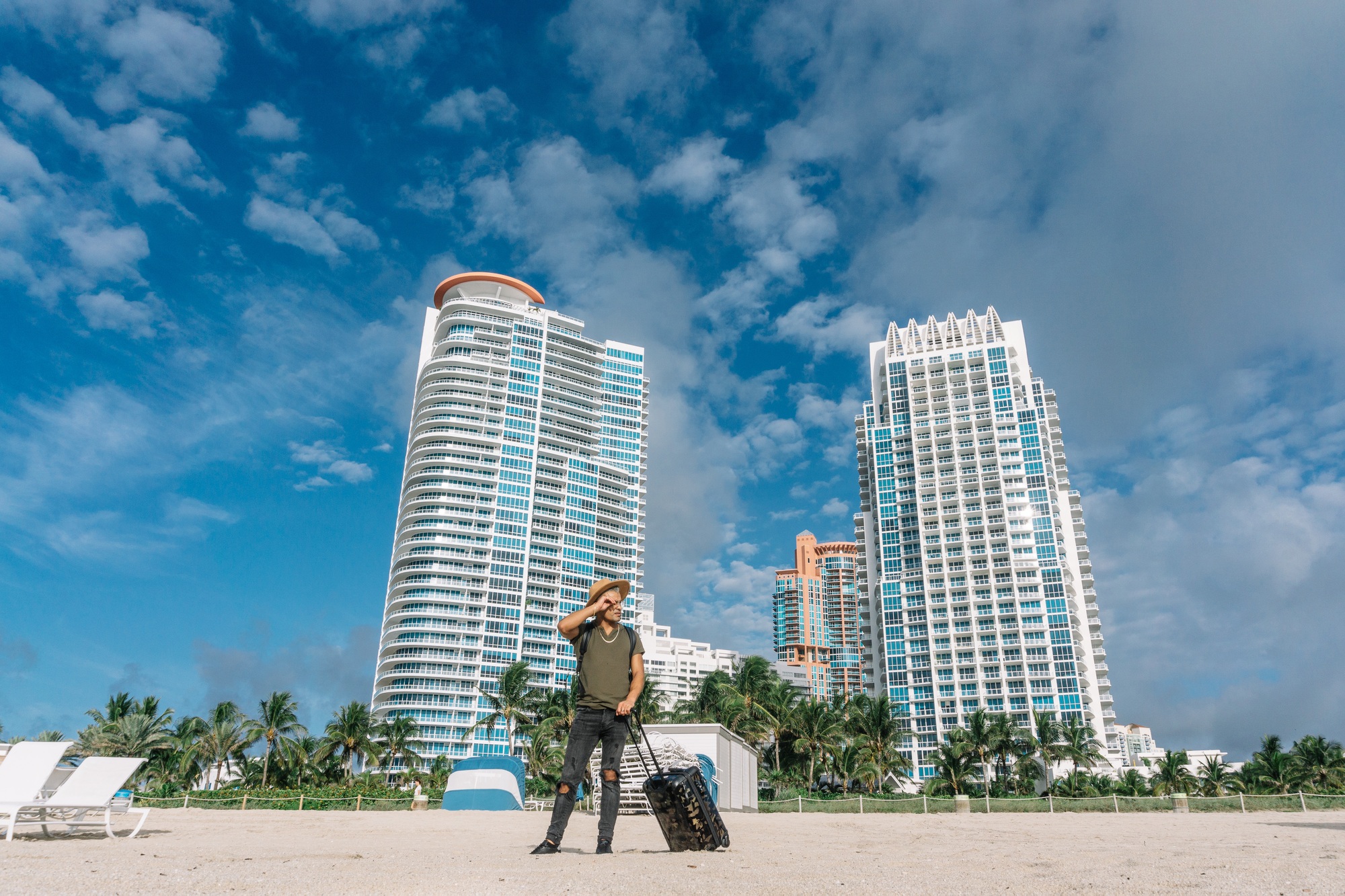 Traveler man for the first time in Miami. South beach buildings background